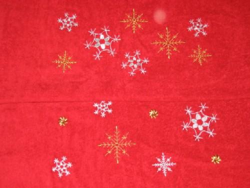 A christmas towel witih stars snow flakes embroidered on it.