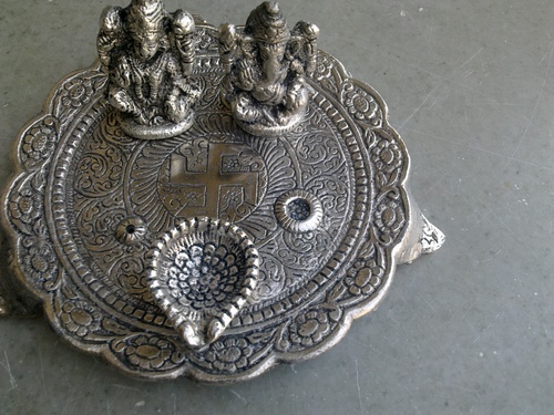 white metal ganeshlaxmi with 1 diya on round base