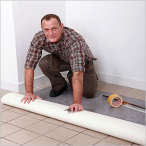व्यक्ति पीवीसी फर्श बिछा रहा है