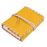 लेदर जर्नल जिसमें ए अल्टी क्रॉस उकेरा हुआ सामने का मुलायम कवर है, साथ में विंटेज लेदर स्ट्रैप बंद करने वाला है।