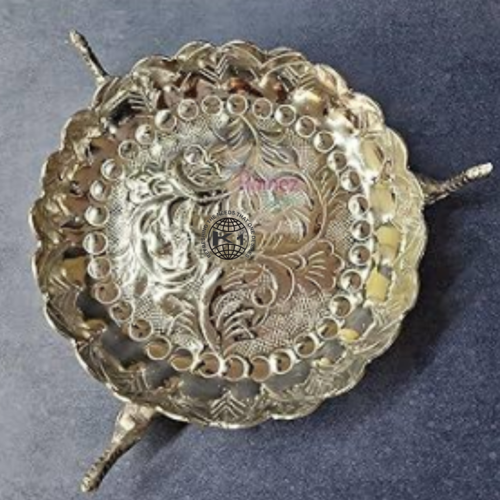 decorative brass Urli bowl with carved legs.