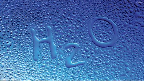 नीले पृष्ठभूमि पर H2O पानी की बूँदें