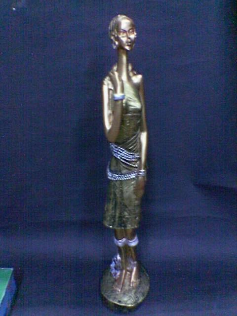 एक सुंदर पॉलीरेसिन की मूर्ति जिसमें एक महिला को पीछे बच्चे के साथ बंधा हुआ दिखाया गया है